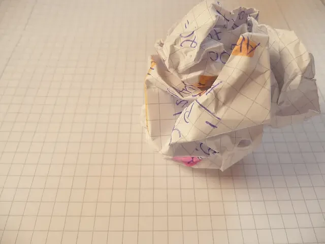 Papel arrugado sobre un cuaderno, símbolo del bloqueo del escritor