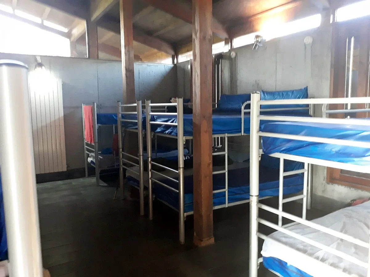 Literas metálicas con colchones azules en un albergue público de peregrinos en Galicia