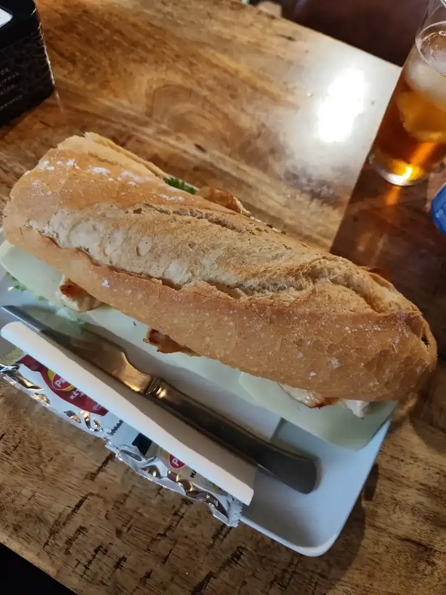 Bocadillo de pan crujiente sobre una mesa de madera
