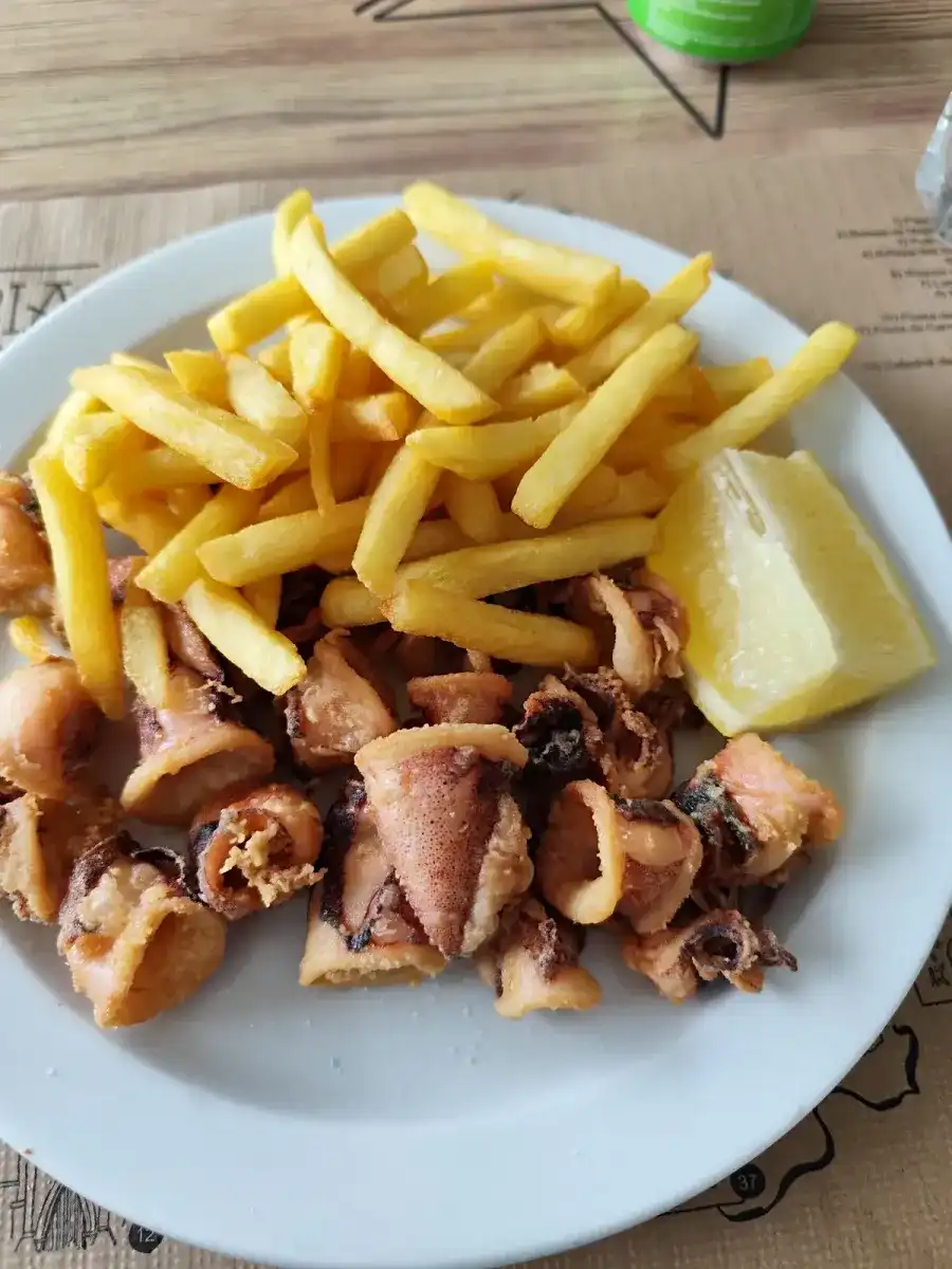 Plato de calamares a la plancha con patatas fritas y limón
