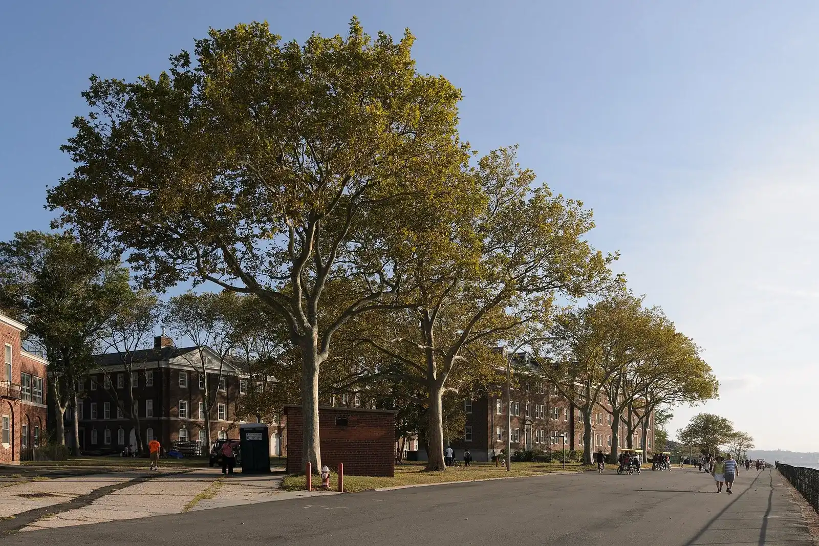 Un paseo con árboles y los edificios de ladrillo de la antigua base de Governors Island
