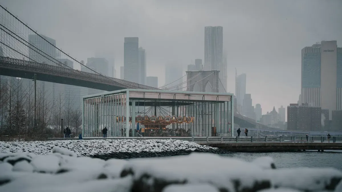 Jane's Carousel en su caja de cristal junto al puente de Brooklyn en un día de nieve