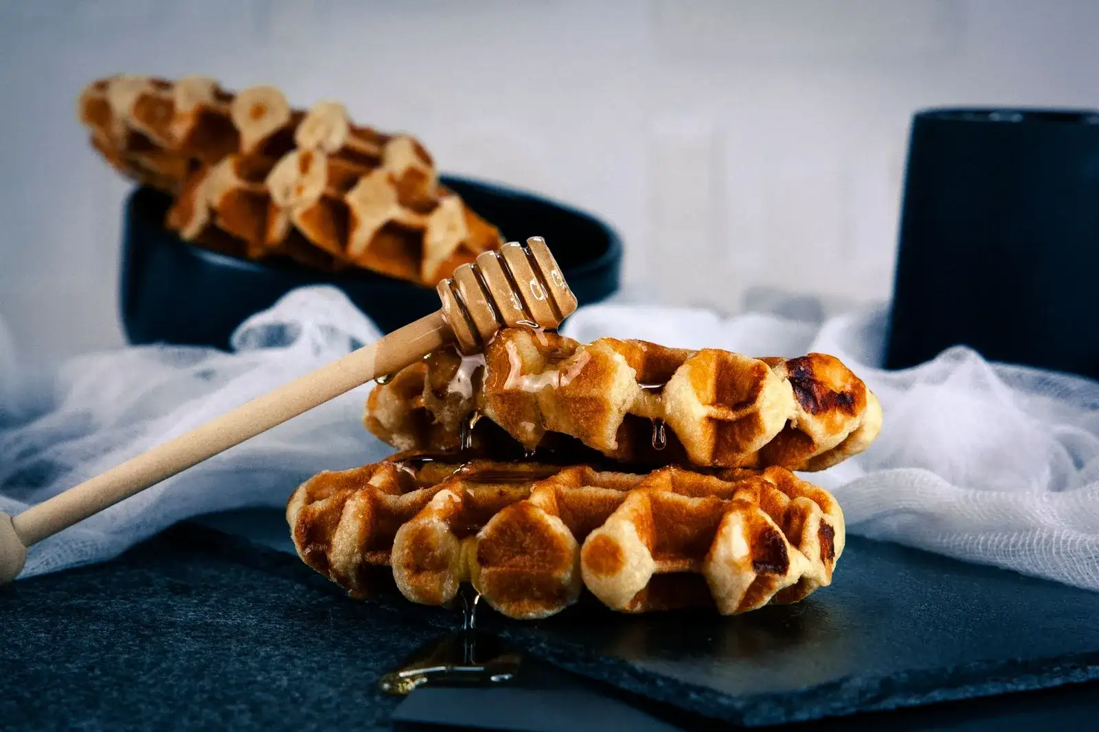 Gofres de Lieja con miel, como los que sirve Wafels & Dinges (foto de referencia, no del puesto)