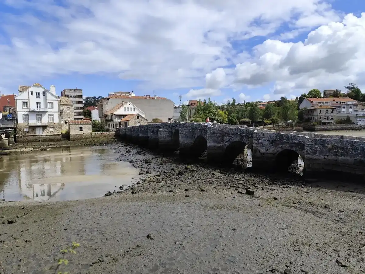 Puente de piedra de varios arcos sobre el río Miñor con la marea baja, entre Sabarís y A Ramallosa