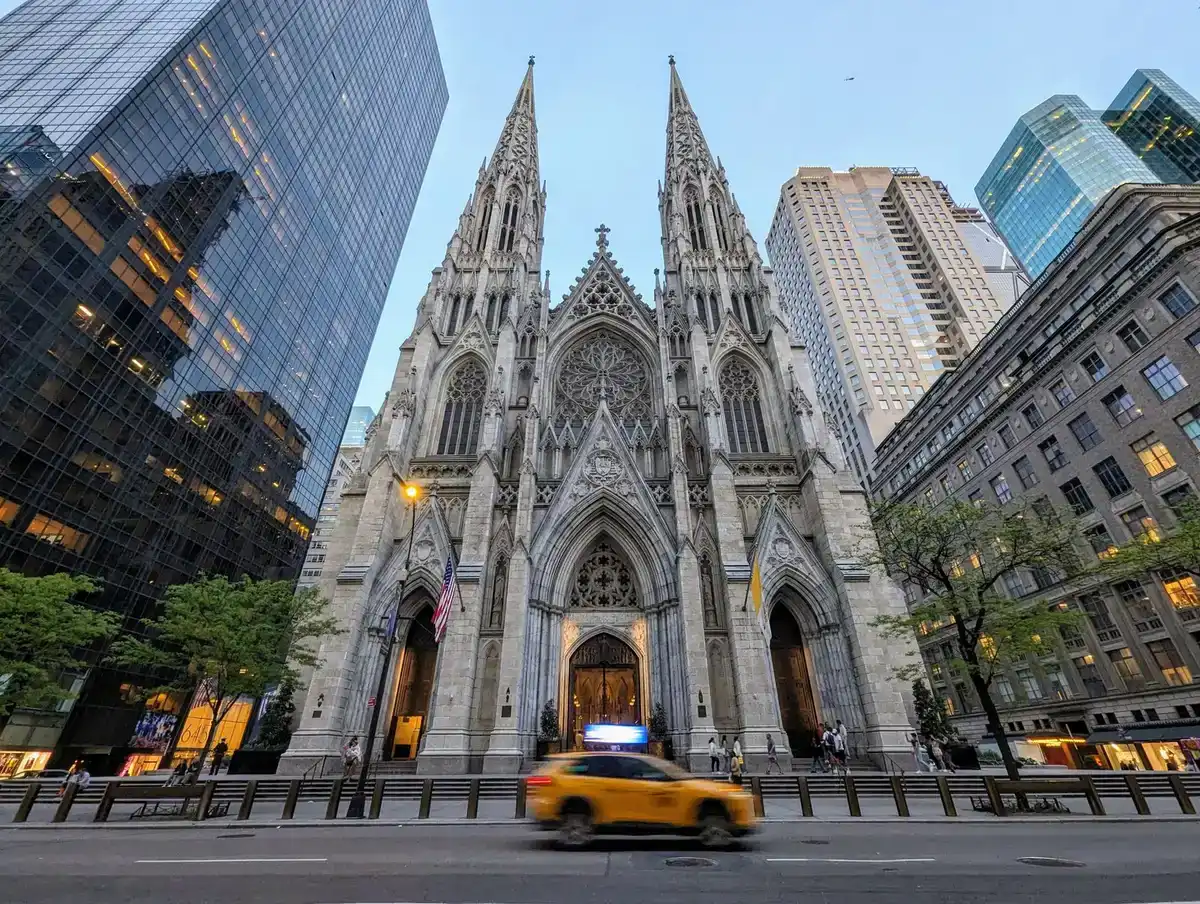 La catedral de San Patricio entre rascacielos en la Quinta Avenida, con un taxi amarillo delante