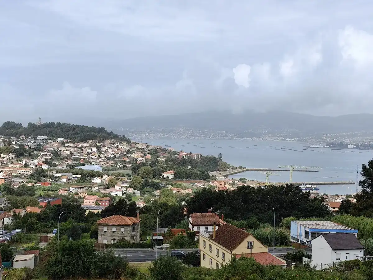 Vista de Vigo y su ría desde una ladera al salir de la ciudad, con casas en primer plano