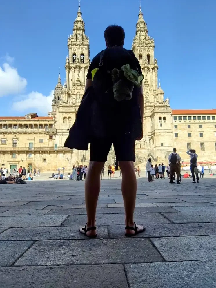 Michiel Das voor de kathedraal van Santiago na de Camino de Santiago langs de kust