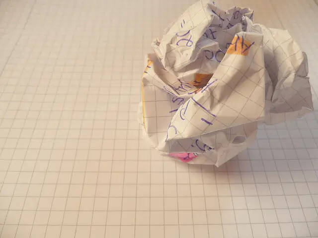 Papel arrugado sobre un cuaderno, símbolo del bloqueo del escritor