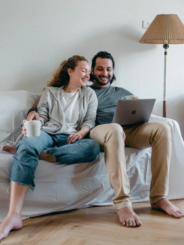 Pareja riendo delante de un portátil